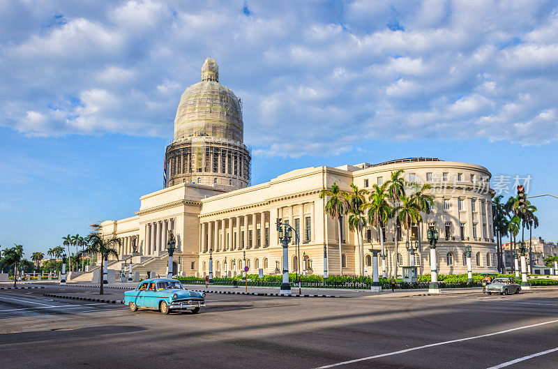 哈瓦那，一辆蓝色经典老爷车在El Capitolio门前行驶